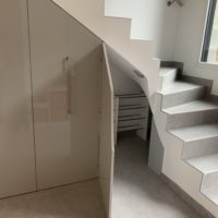 création d'un meuble sous escalier sur-mesure en melaminé gris extra brillant de marque Egger sur coulisse équipé soit de penderie, d'étagére ou de range chaussure