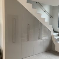 création d'un meuble sous escalier sur-mesure en melaminé gris extra brillant de marque Egger sur coulisse équipé soit de penderie, d'étagére ou de range chaussure