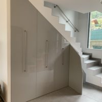 création d'un meuble sous escalier sur-mesure en melaminé gris extra brillant de marque Egger sur coulisse équipé soit de penderie, d'étagére ou de range chaussure