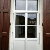 installation d'une porte fenêtre en PVC sur-mesure avec imposte fixe, porte oscillot-battante le chantier est dans le Grésivaudan
