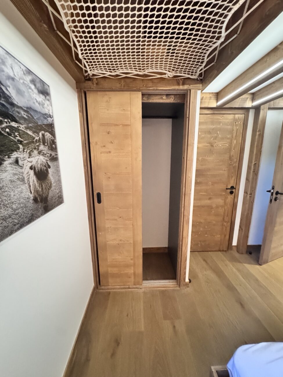 Placard en bois à portes coulissantes installé sous la mezzanine