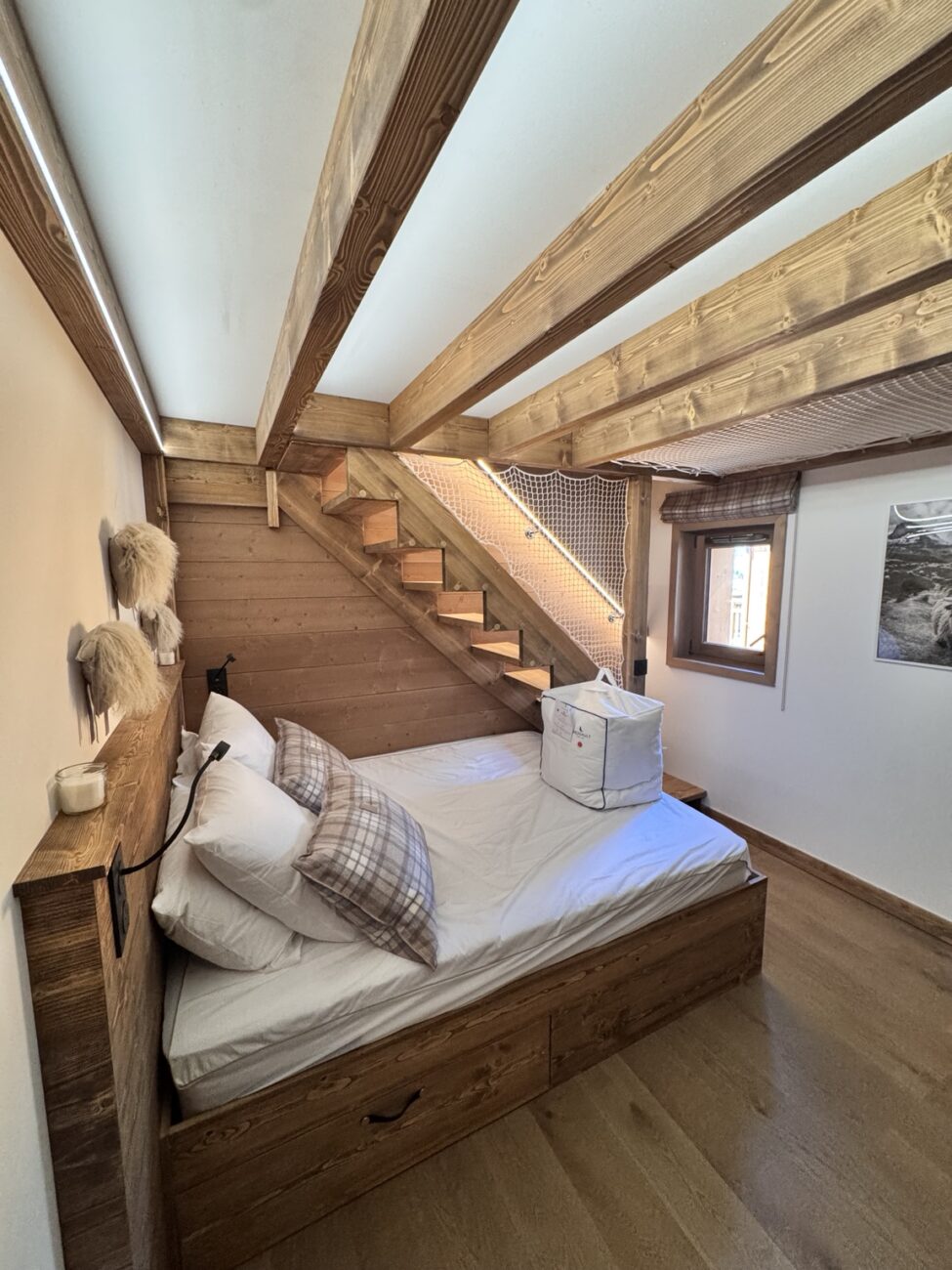 Lit double en sapin avec tiroirs de rangement sous l’escalier de la mezzanine